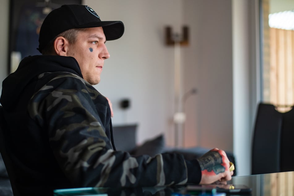 Marcel Eris (32) sitzt während eines Interviews in seiner Wohnung.