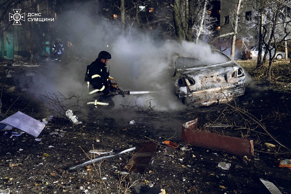 Feuerwehrleute in Sumy löschen das Feuer nach einem russischen Raketenangriff, der ein mehrstöckiges Wohnhaus getroffen hat.