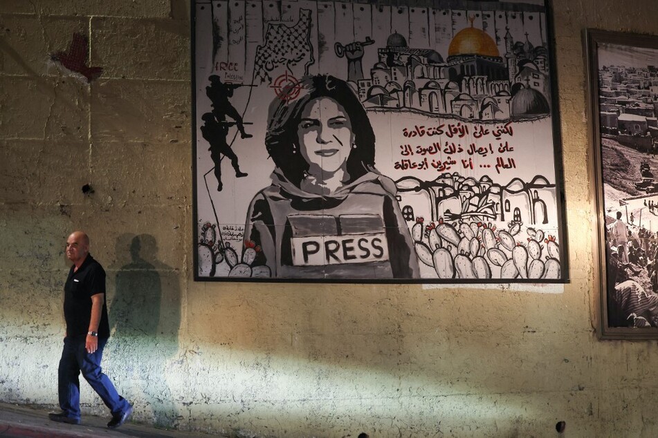 A man walks past a mural depicting slain Palestinian-American journalist Shireen Abu Akleh on a street in the town of Umm Al-Fahm in northern Israel.