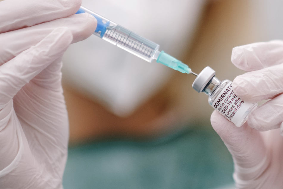 Eine Mitarbeiterin im Gesundheitswesen zieht in einem Impfzentrum eine Spritze mit Covid-19 Impfstoff auf.