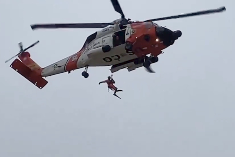 Ein Mitglied der Küstenwache seilte sich aus dem Helikopter ab.