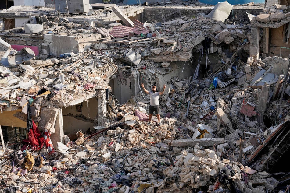 Ein Mann, der nach der Bekanntgabe eines ersten Waffenstillstandsabkommens zwischen den Vereinigten Staaten und dem Iran in sein Dorf zurückkehrt und steht auf den Trümmern seines zerstörten Hauses.