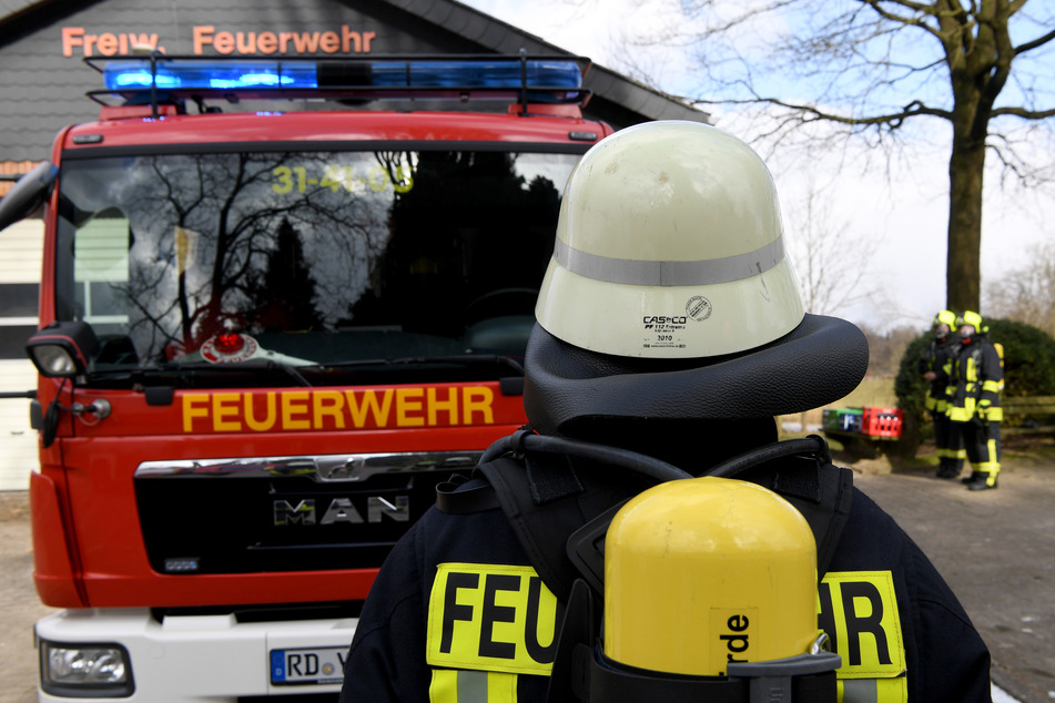 Eine Feuerwehrfrau steht vor einem Feuerwehrauto. (Symbolbild)