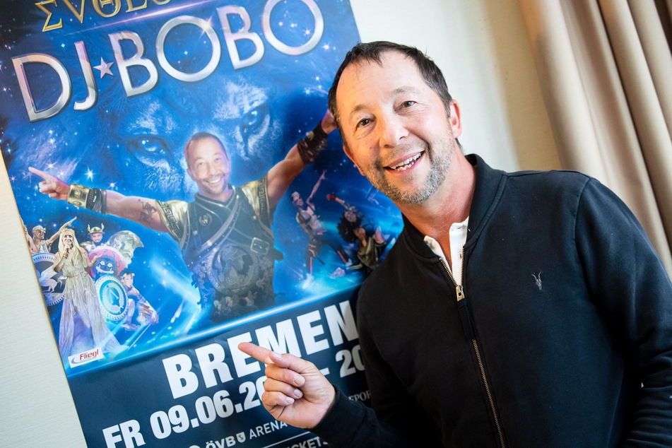 Der Schweizer Musiker DJ Bobo (54, René Peter Baumann) steht vor seinem Tourplakat.