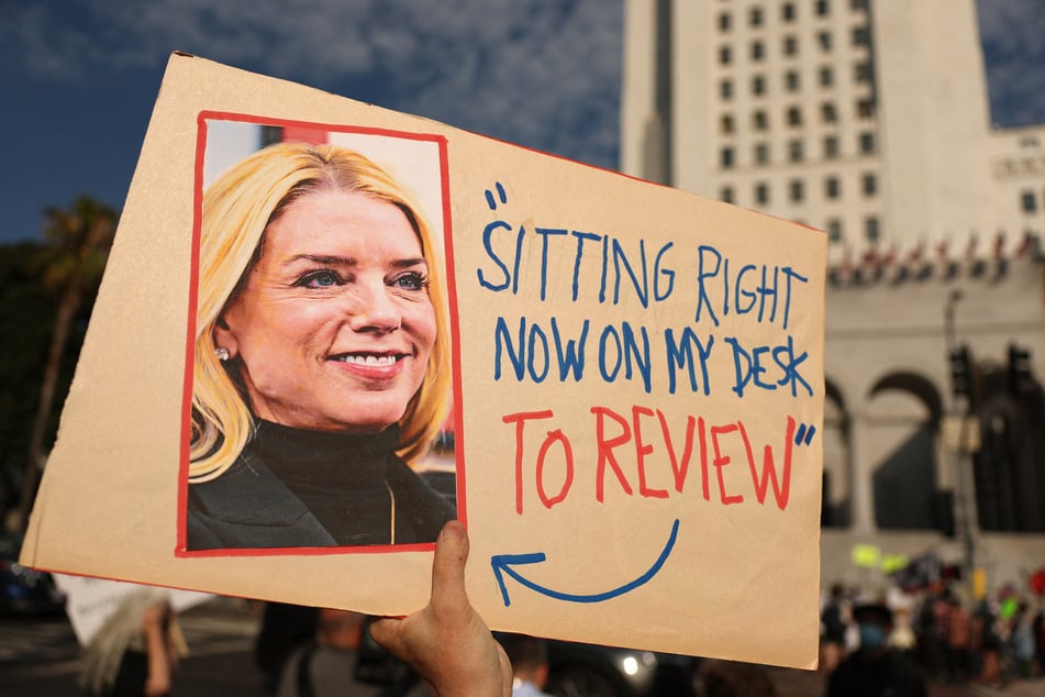 A person holds a sign with a photo of US Attorney General Pam Bondi and featuring a quote in reference to the Epstein files during a protest in Los Angeles, California, on July 17, 2025.