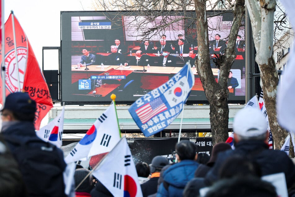 Supporters of South Korean ex-president Yoon Suk Yeol watch the proceedings of his sentencing trial outside the Seoul Central District Court in Seoul on February 19, 2026.
