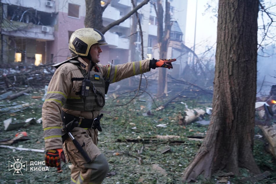 Drohnen-Terror in Kiew: Ein Feuerwehrmann steht vor einem beschädigten Mehrfamilienhaus.