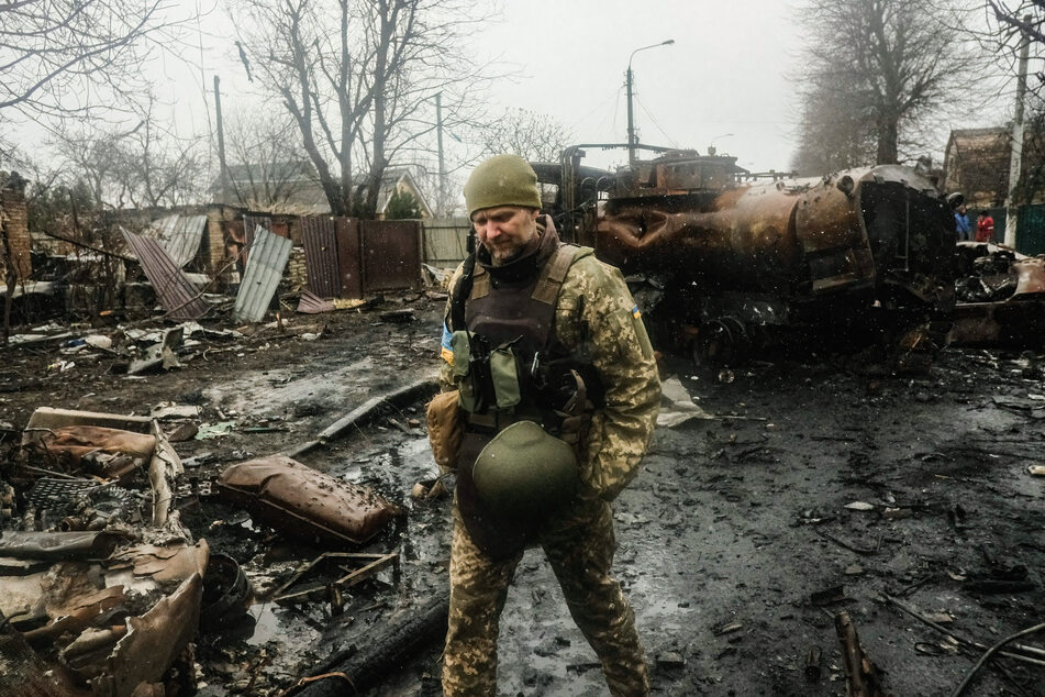Ein ukrainischer Soldat schreitet durch die Straßen der Stadt Butscha, dort hat die russische Armee zuvor ein regelrechtes Massaker angerichtet.