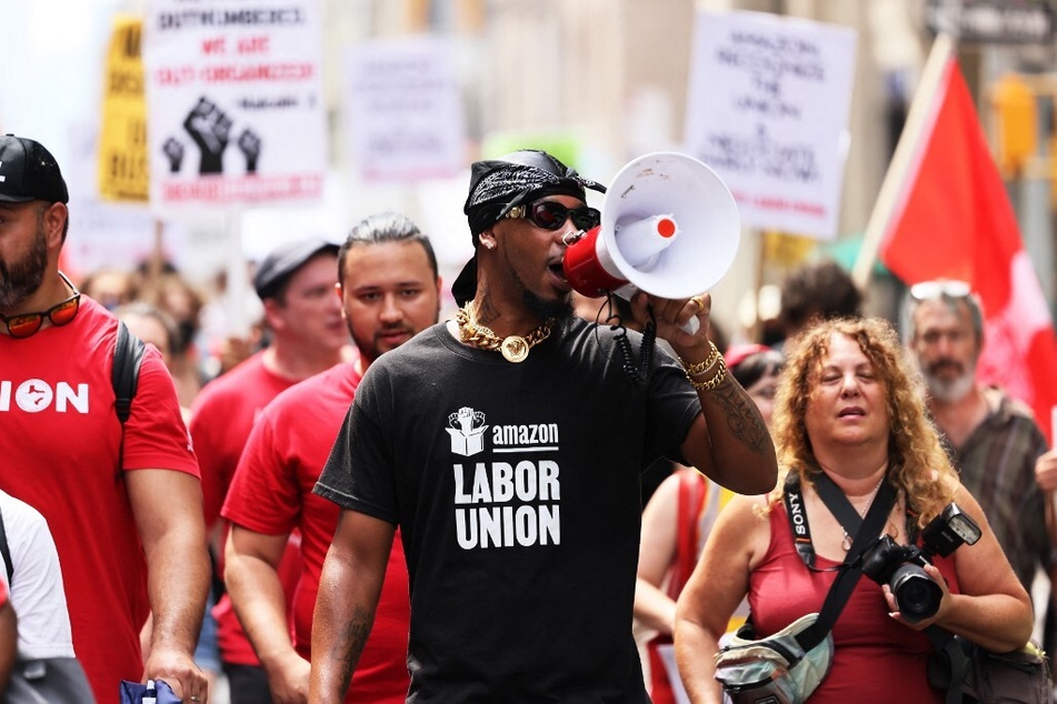 The Amazon Labor Union, led by President Christian Smalls (c.), has celebrated the passage of the Warehouse Worker Protection Act in New York.
