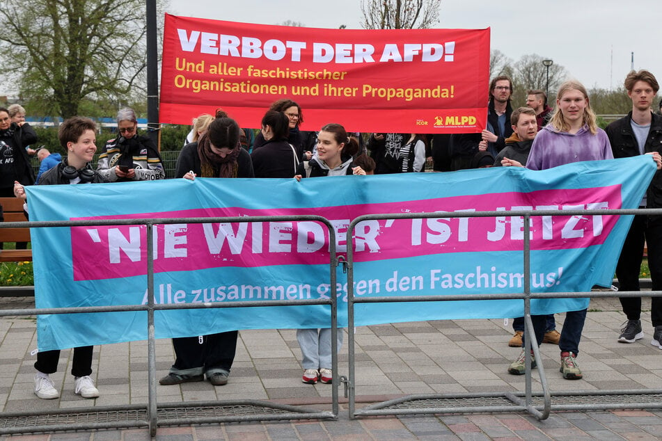 Demonstranten protestieren gegen einen Info-Stand der AfD in Rostock.