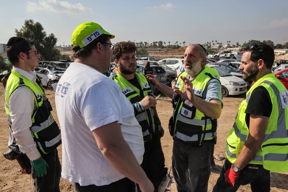 Israeli volunteers from the ultra-Orthodox Jewish emergency response team Zaka gather by vehicle destroyed in the October 7 attacks.
