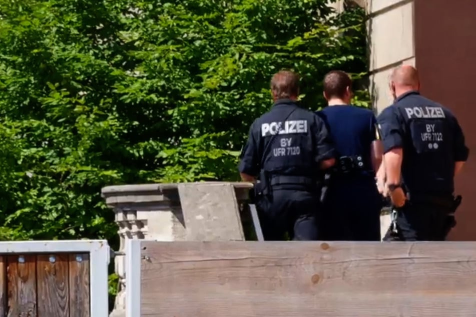 Polizisten bringen den Tatverdächtigen (M.) in das Gerichtsgebäude in Schweinfurt.