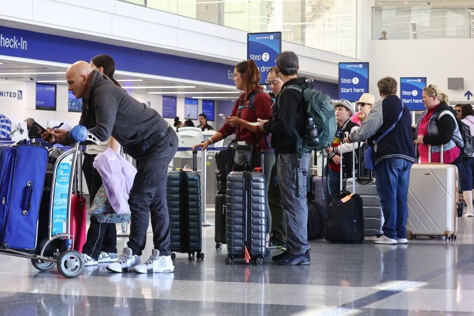 Travelers stand at a United Airlines check-in area at Los Angeles International Airport on January 8, 2024, as many flights are canceled.