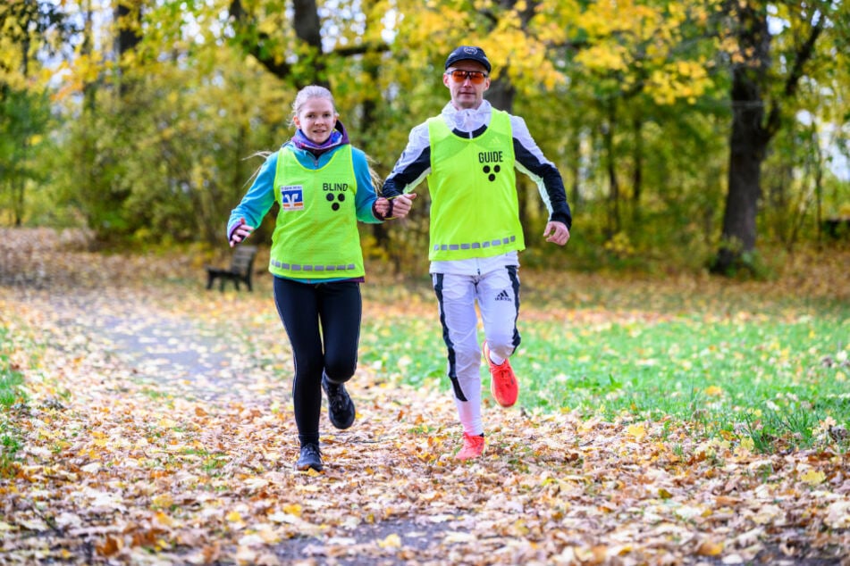 Silja Schray (18) läuft mit Guide Jan Oettel (38) flott und sicher auf dem Parkweg.