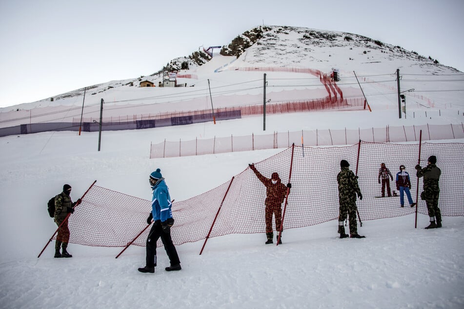 Vor dem Weltcup, Abfahrt, Herren: Schweizer Soldaten sperren den Zuschauerbereich vor der Skipiste mit einem Zaun ab. Die diesjährige Ausgabe des Weltcup-Rennens soll wegen eines Anstiegs der Coronafälle in der Region nun doch nicht stattfinden.