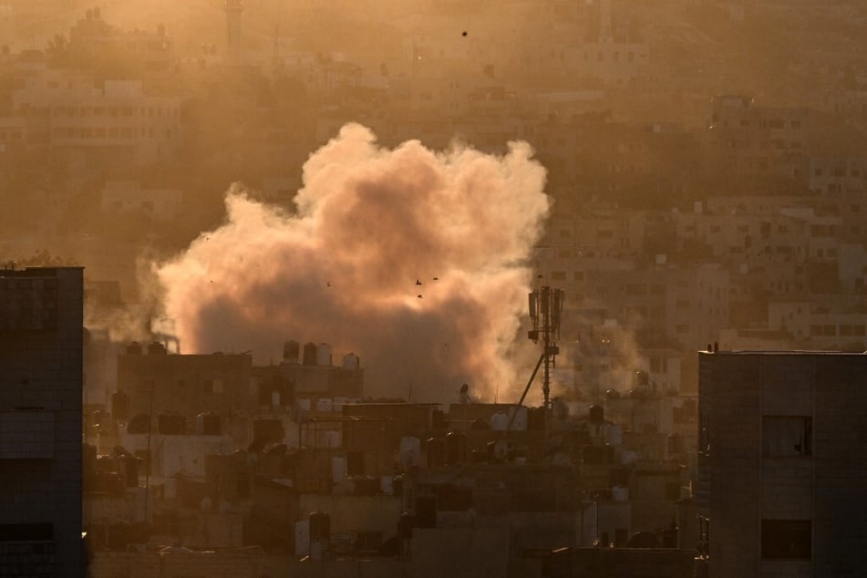 A plume of smoke rises during an ongoing Israeli raid in the occupied West Bank's Jenin refugee camp.