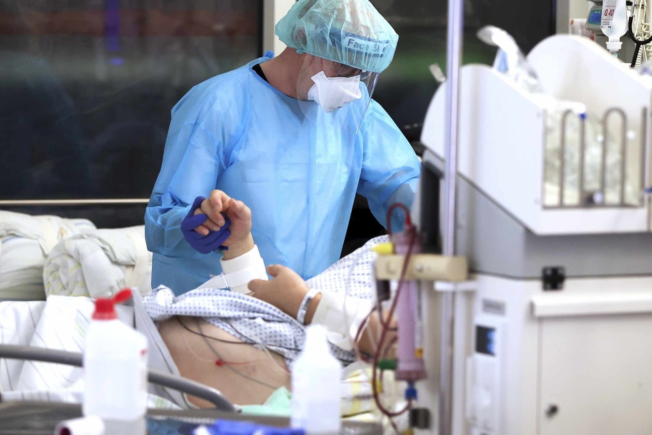 Ein Arzt steht an einem Bett eines Corona-Patienten auf der Intensivstation.