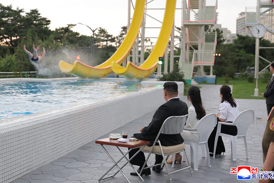 Während erste Urlauber die Wasserrutschen einweihen, sitzt Kim zur Begutachtung in vorderster Reihe.