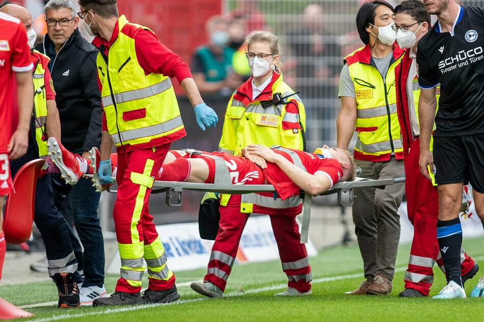 FCU-Innenverteidiger Timo Baumgartl (M.) wurde nach einem Zusammenstoß mit Fabian Klos (r.) von Arminia Bielefeld vom Spielfeld getragen.