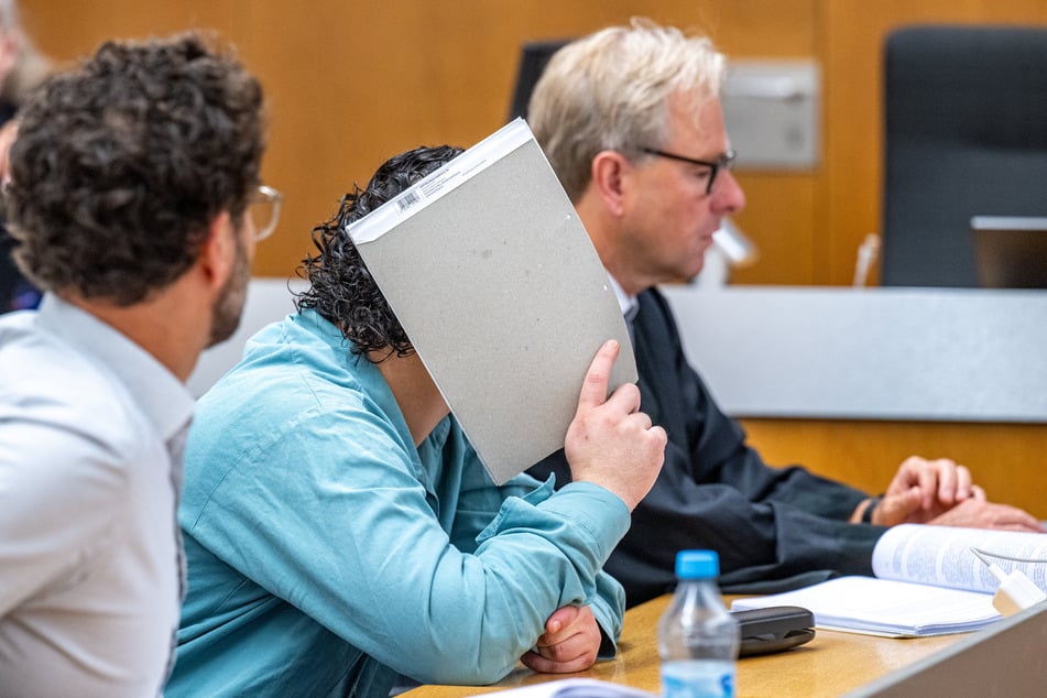 Der Angeklagte (M.) sitzt im Verhandlungssaal des Landgerichts neben seinem Verteidiger Thomas Krimmel (r).