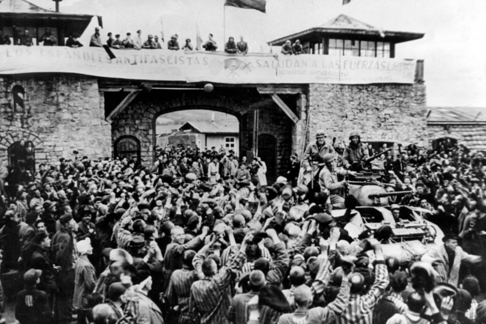 Gefangene des Konzentrationslagers Mauthausen jubeln ihren amerikanischen Befreiern zu.