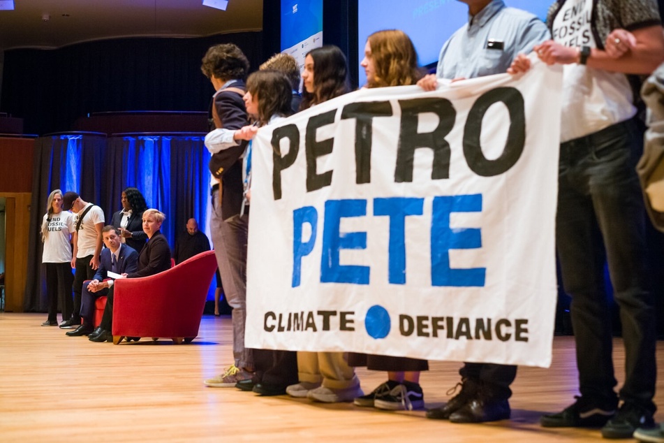 Climate Defiance activists take the stage at Baltimore's Meyerhoff Symphony Hall to confront US Transportation Secretary Pete Buttigieg over his department's approval of harmful oil extraction projects.