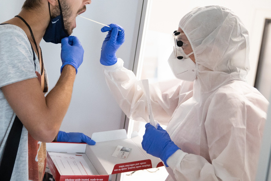 Eine Mitarbeiterin führt am Flughafen Hamburg einen Corona-Test durch.