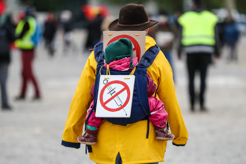 Eine Teilnehmerin einer Protestkundgebung der Initiative "Querdenken" trägt in Stuttgart ein Schild gegen Impfungen auf ihrem Rücken.