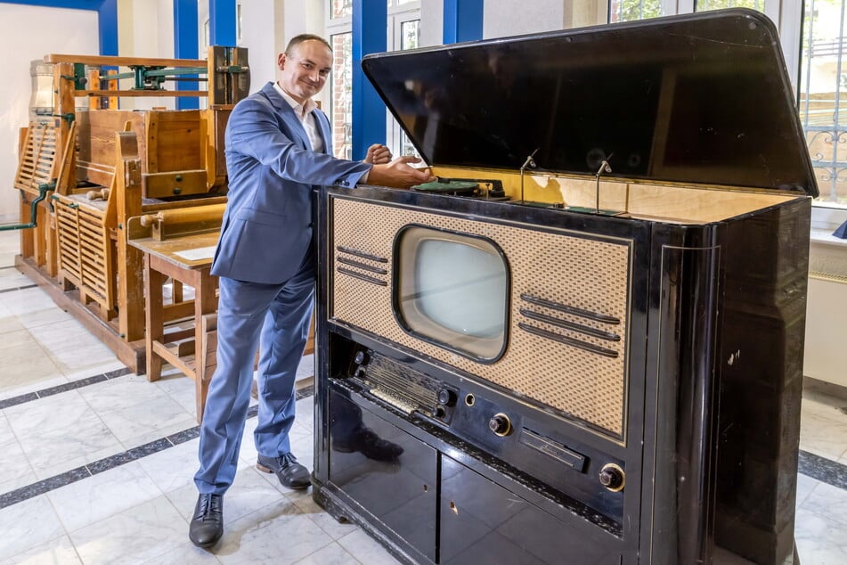GGG-Sprecher Erik Escher (39) präsentiert den Fernseh- und Radio-Schrank aus dem "VEB Sachsenwerk" Radeberg.
