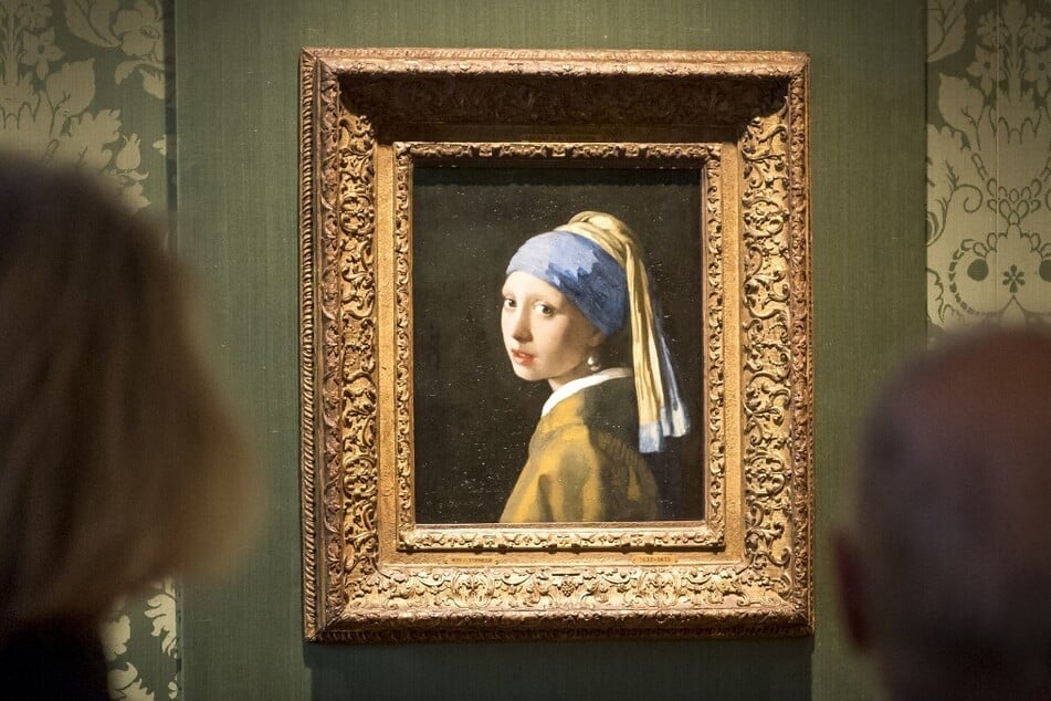 Visitors looks at the Johannes Vermeer's painting Girl with a Pearl Earring at the Mauritshuis museum in The Hague.