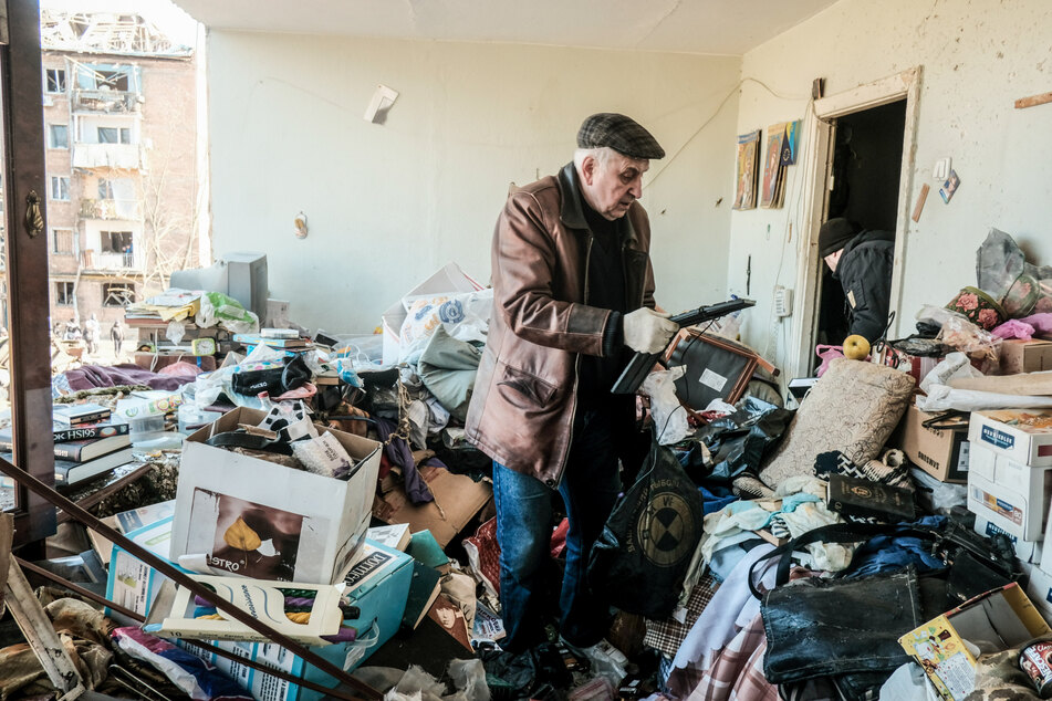 Bewohner des Kiewer Stadtteils Podil durchsuchen die Trümmer ehemaliger Wohnungen nach einem russischen Luftangriff in dem Wohnviertel nach Habseligkeiten und möglichen Toten.