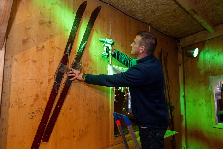 Als Dekoration schraubt Nico Thierbach (41) alte Ski an die Holzwände der Hütte.