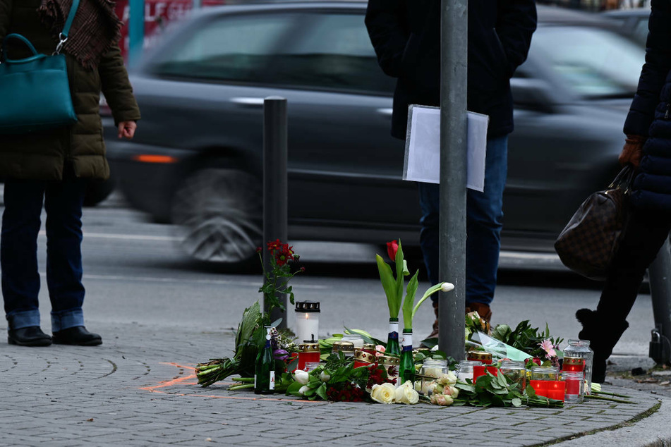 Blumen liegen an der Stelle, wo in Frankfurt-Sachsenhausen am 13. Februar 2021 zwei Fußgänger bei einem Autounfall ums Leben kamen.