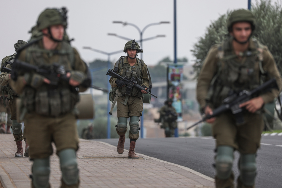 Israelische Soldaten gehen eine Straße entlang und sichern das Gelände in der Stadt in der Nähe des Gazastreifens.