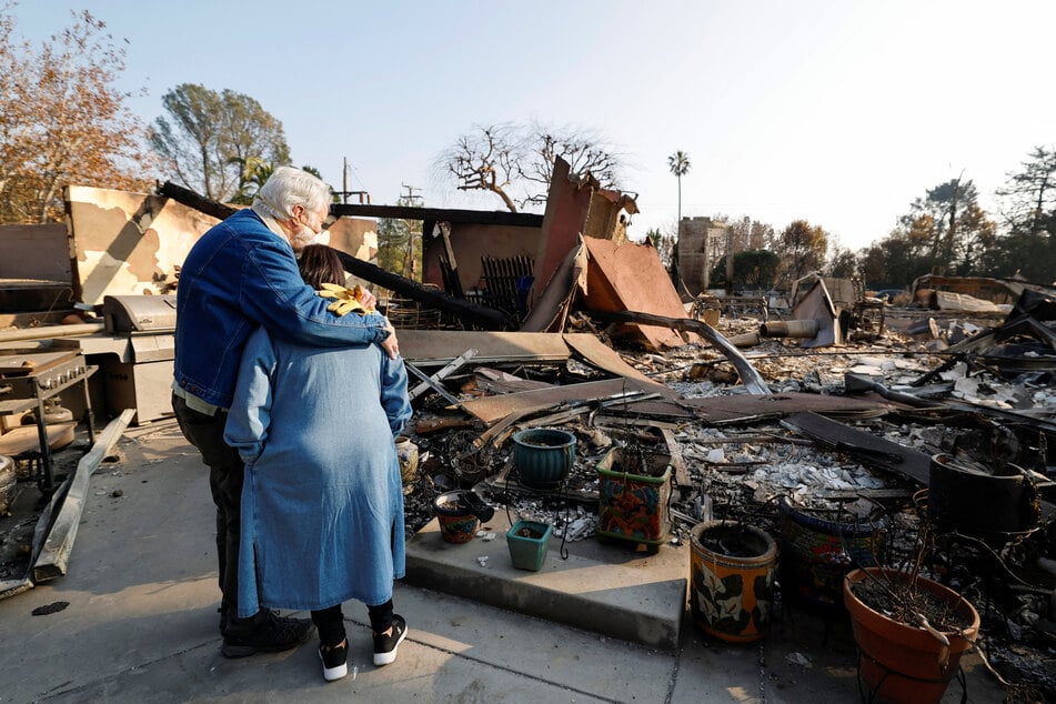 A couple embrace as they return to their home that burned down in the Eaton Fire in Altadena, California.