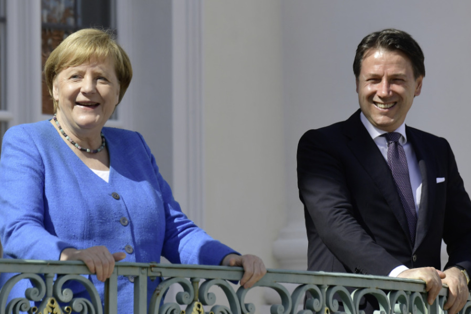 Brandenburg, Meseberg: Bundeskanzlerin Angela Merkel (CDU) zeigt sich mit Italiens Ministerpräsident vor ihren Beratungen auf einem Balkon des Gästehauses der Bundesregierung auf Schloss Meseberg.