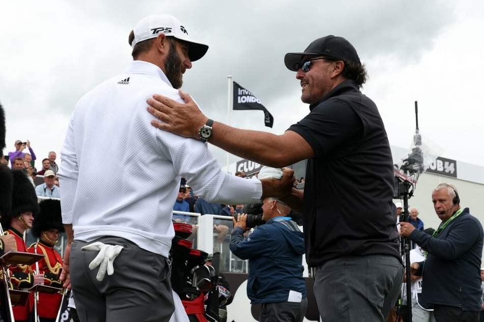 US golfers Dustin Johnson (l.) and Phil Mickelson (r.) shake hands on the first tee on the first day of the LIV Golf Invitational Series event.