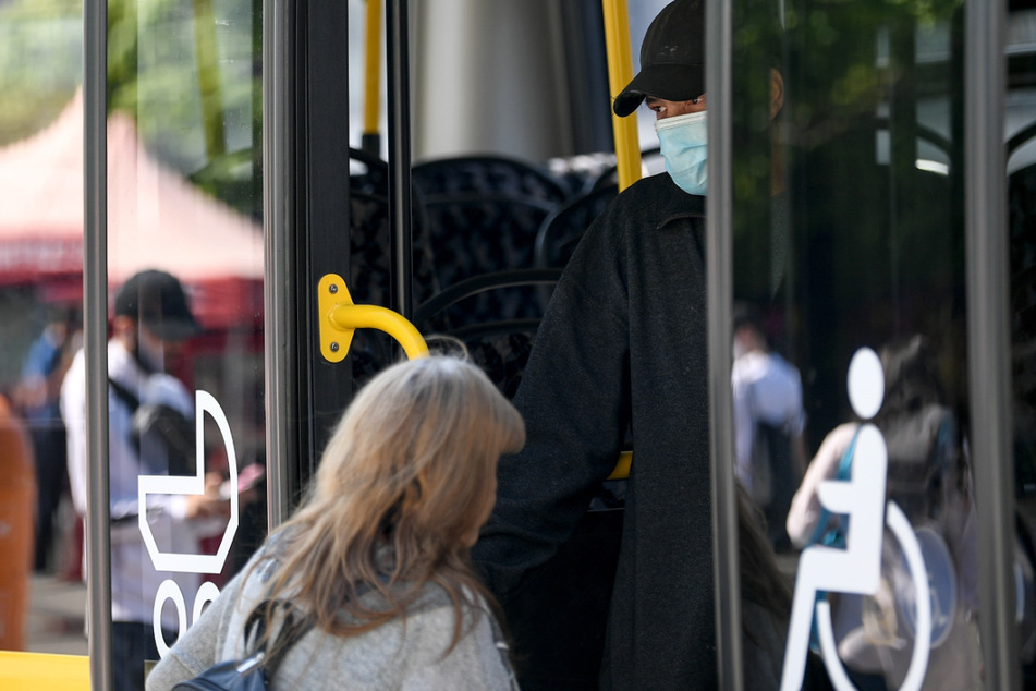 Ein junger Mann trägt einen Nasen-Mund-Schutz bei der Fahrt in einem Bus der BVG. Bald können Fahrgäste auch wieder vorne einsteigen.