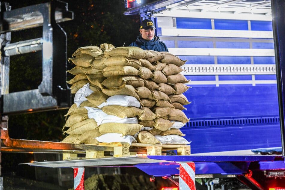 Einsatzkräfte des Technischen Hilfswerks (THW) laden am Logistikzentrum Sandsäcke für Süddeutschland.