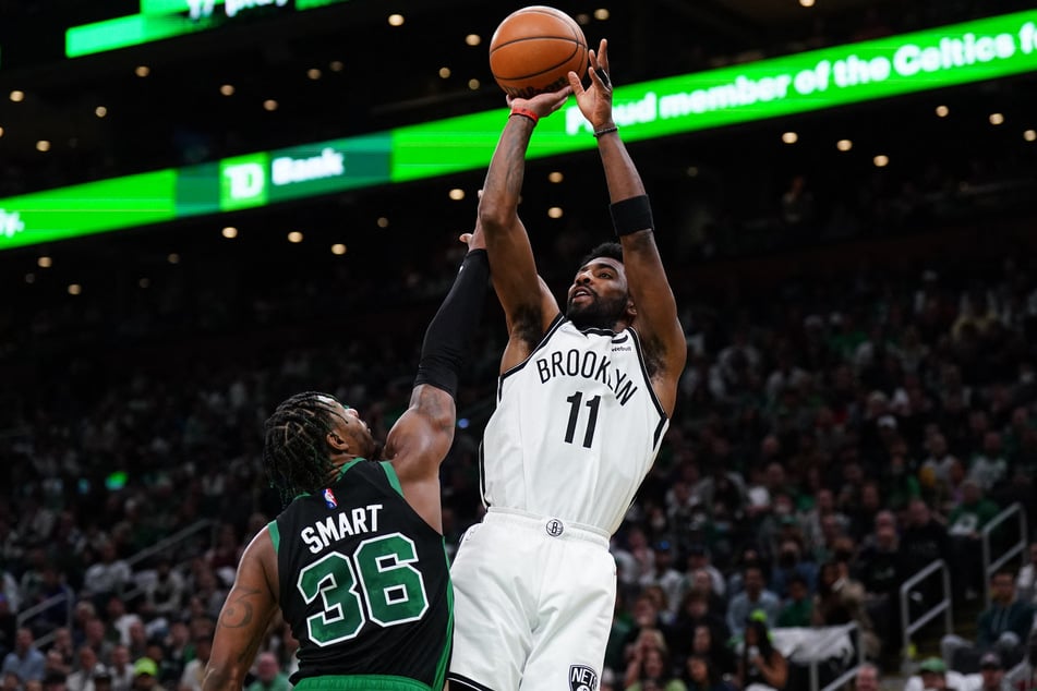 The Nets' Kyrie Irving goes up to shoot as the Celtics' Marcus Smart goes in for the block.