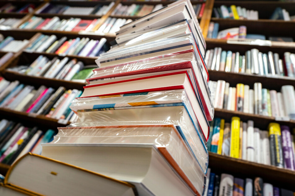 Ein Stapel neuer Bücher liegt auf einem Verkaufstisch in einer Buchhandlung.