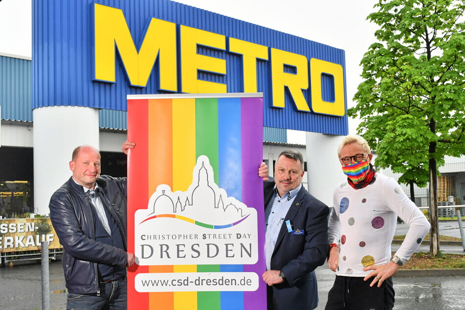 CSD-Chef Ronald Zenker (48, v.l.), Metro-Betriebsleiter Jens-Uwe Hauffe (51) und Unternehmer Wolle Förster (66) stellen ein Regenbogen-Plakat auf.