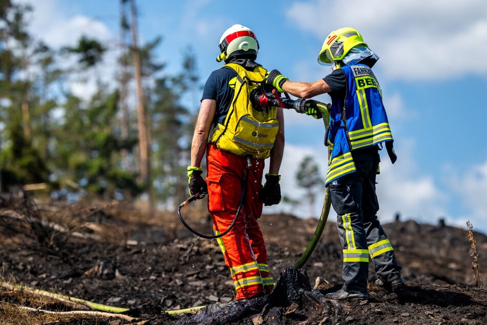 Einsatzkräfte füllen einen Löschrucksack nach.