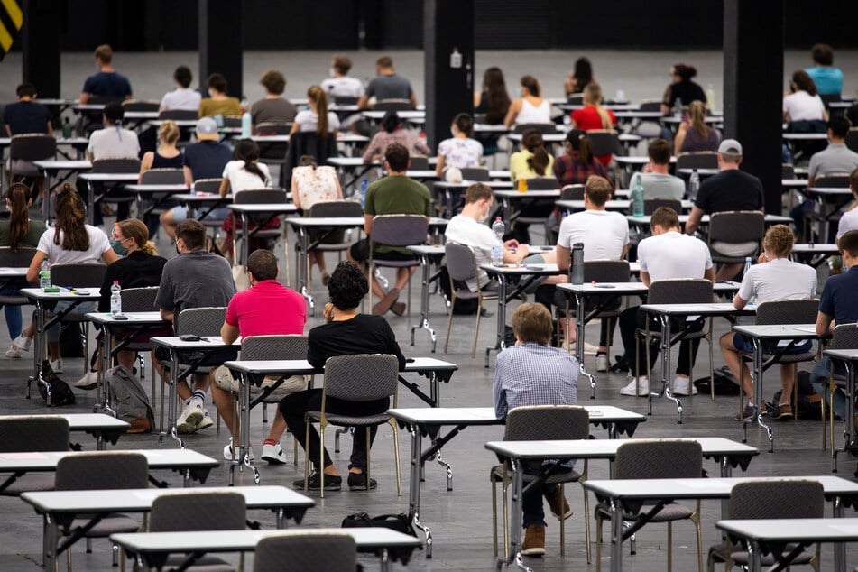 Studenten bei Prüfungen in der Messehalle der Messe Köln.