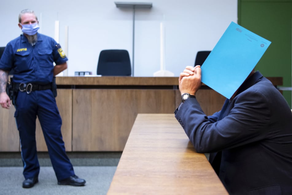 Der wegen sexuellen Missbrauchs von Kindern und Schutzbefohlenen sowie sexueller Nötigung angeklagte Mann (r.) sitzt auf seinem Platz.