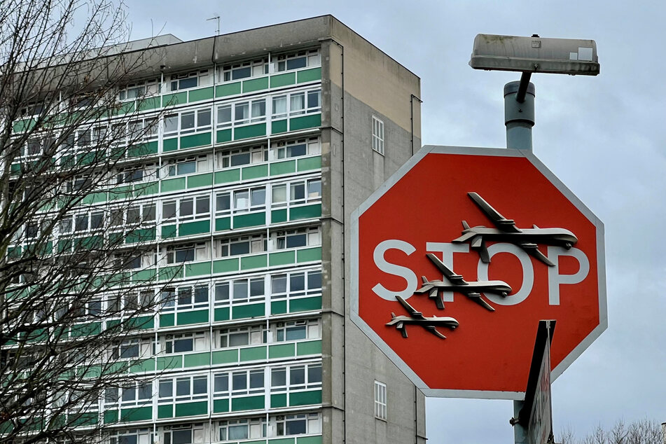 Banksy artwork depicting drones covers a stop sign in London was removed shortly after it appeared, leading to two arrests.