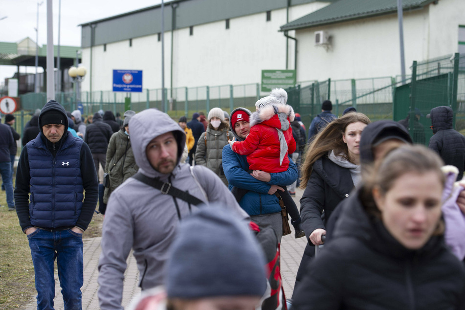 Ukrainian people are seen crossing the border into Poland on Friday.