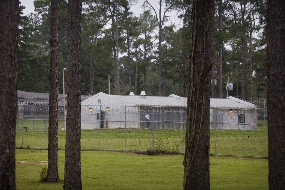 A Black youth at the Arthur G. Dozier School for Boys is photographed tending to the school's kennels on October 13, 2009.