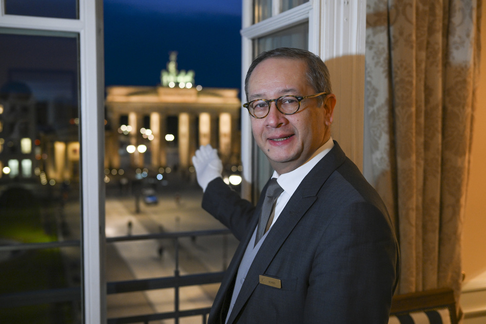 Butler Ricardo Dürner steht in der Royal Suite im Hotel Adlon und präsentiert den Ausblick auf das Brandenburger Tor.
