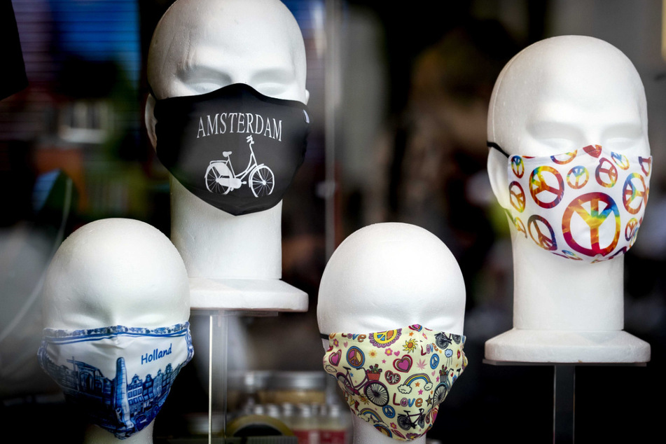 Stoff-Masken sind auf Modellköpfe in einem Schaufenster in Amsterdam dekoriert.